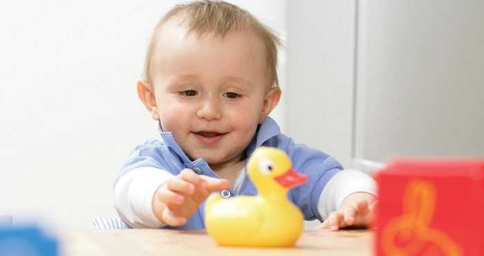 5-месячный малыш играется 5-месячный малыш играется с уткой