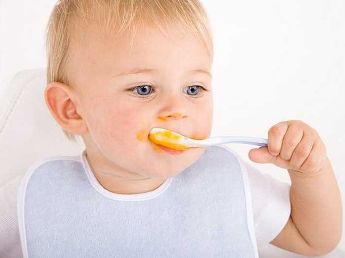 Малыш ест пюре Знакомство малыша с ложкой и поедание пюре