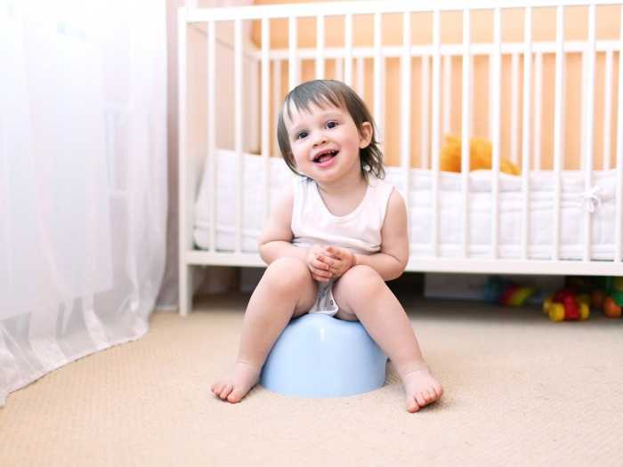 Маленький ребенок сидит на горшке Приучение ребенка к горшку начинается с 3 лет