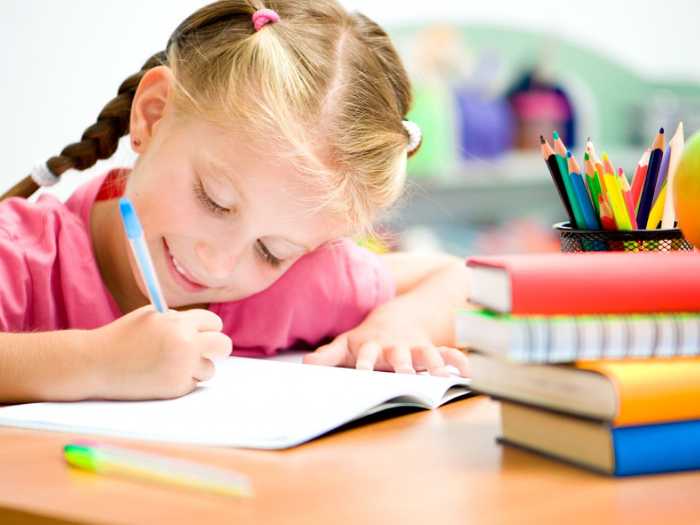Девочка за письмом Девочка учится писать ручкой