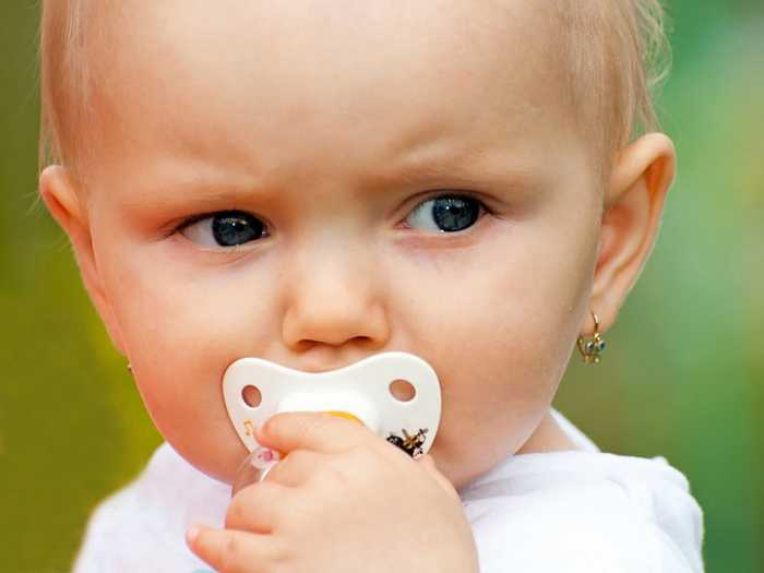 Маленькая девочка сосет соску Процесс отучения от соски может затянуться