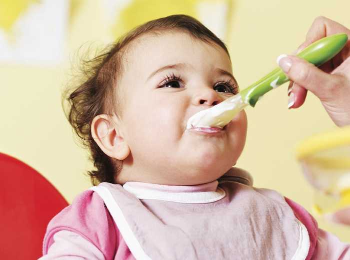 Маленький ребенок за обедом Каша для ребенка 11 месяцев в качестве обеда