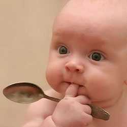 Малыш с ложкой Малыш держит ложку в руках