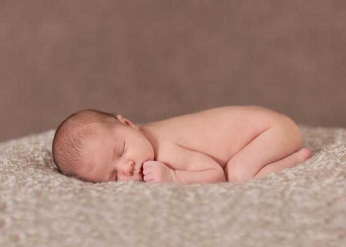 Новорожденный спит Новорожденный спит на животе