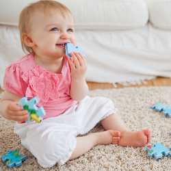 Ребенок на ковре с пазлом Ребенок играет в пазлы на ковре