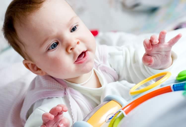 Ребенок тянется к игрушке