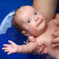 Купание младенца Малыша купают с пеной