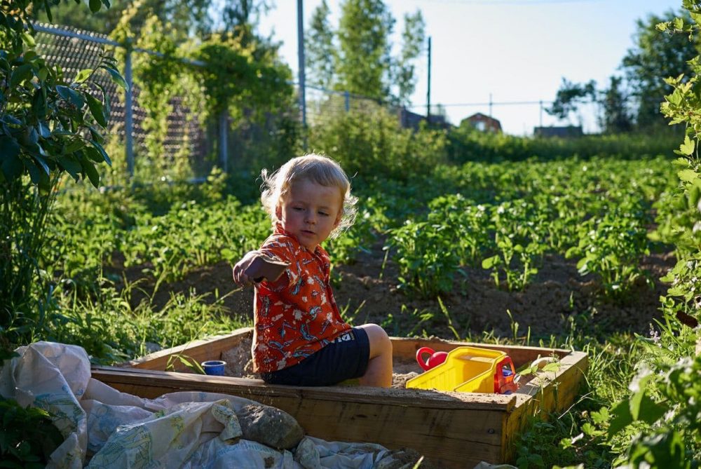 ребёнок пересыпает песок